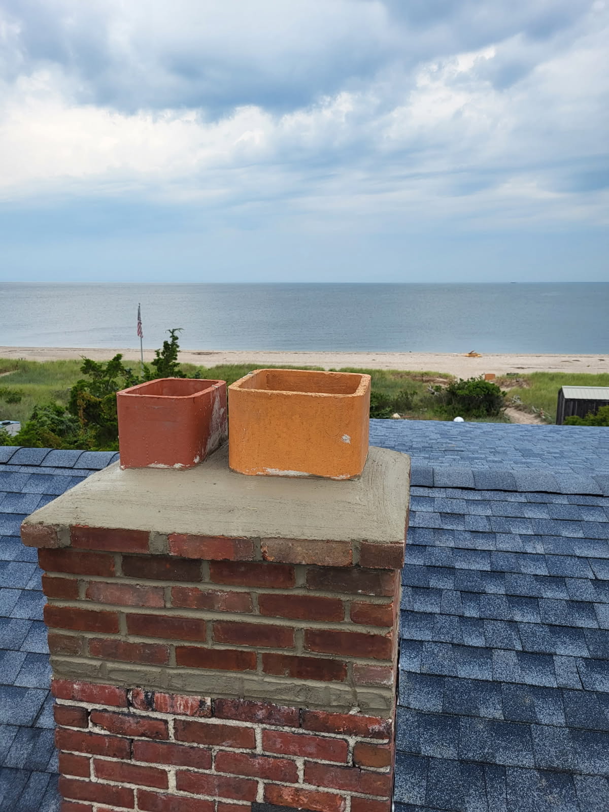 Rebuilt brick chimney with fresh mortar and a new concrete crown on a Long Island home